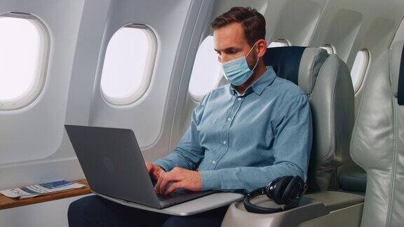 在飞机上带着笔记本电脑的人