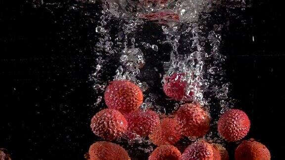 荔枝果落入飞溅的水中的超慢动作柠檬水烹饪概念拍摄于高速影院摄像机4k1000fps