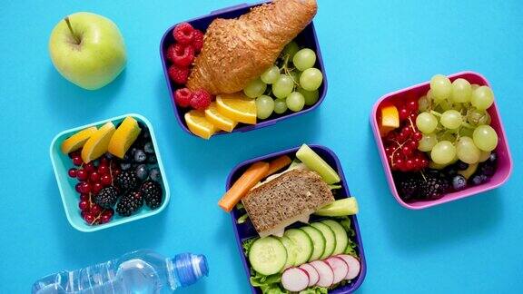 学校午餐盒的照片蓝色的背景上有各种健康营养的食物