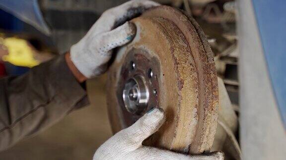 师傅将一个旧的汽车制动鼓安装在一个新的车轮轴承上