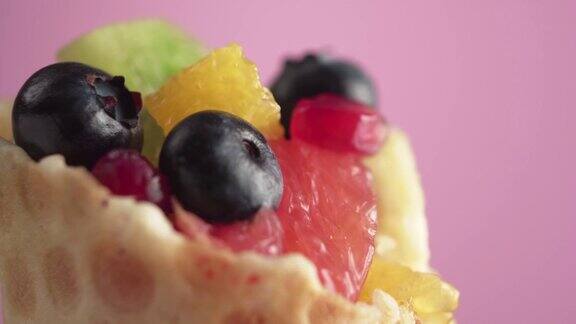 新鲜多汁的水果沙拉和蓝莓在一个华夫饼篮子在粉红色的背景微距拍摄素食食品