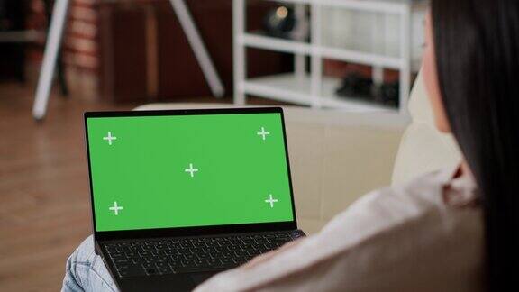 妇女的笔记本电脑与绿色屏幕色度键模板显示