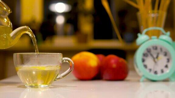 把凉茶倒进厨房的杯子里顺势疗法茶壶里的健康酊