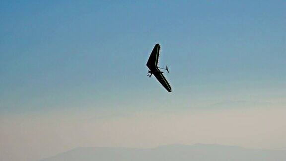 令人惊叹的滑翔机剪影在高山脉