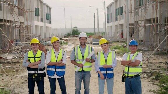 一个多元化的专家团队的画像一名拉丁投资者一名工程师一名亚洲女工一名高级电工在现场的房屋建设开发项目中微笑