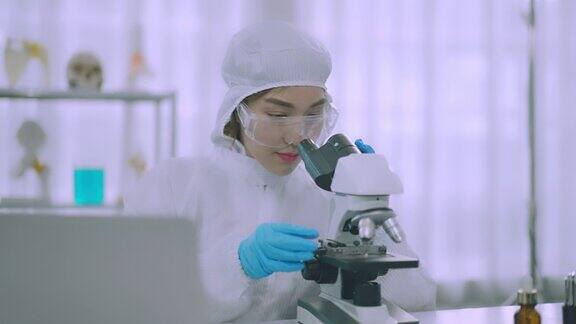 在实验室用显微镜进行科学实验的女科学家