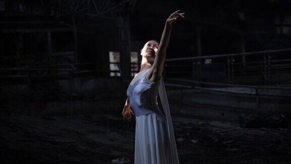 年轻美丽的芭蕾舞女演员在黑暗中与烟背光跳舞