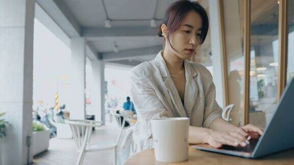 亚洲女商人在咖啡馆使用笔记本电脑