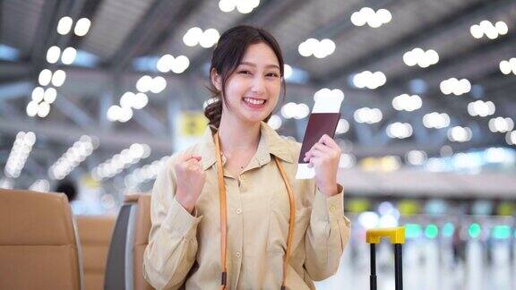 亚洲妇女在机场等待离开假期假期肖像微笑的亚洲年轻女子看着相机面部表情快乐