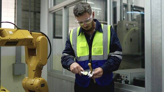 在工厂从事防护工作的技术工程师负责检查工业机器人机械臂上的机器人工艺和QC部件