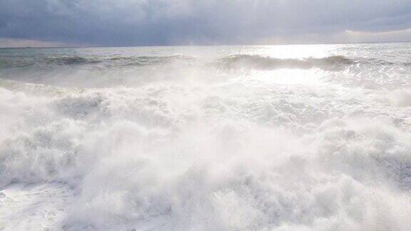 巨浪形成拍打着海岸溅起白色的泡沫