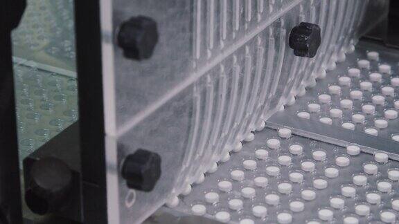 药片在吸塑包装沿传送带移动生产过程中自动装配线的特写制药生产线