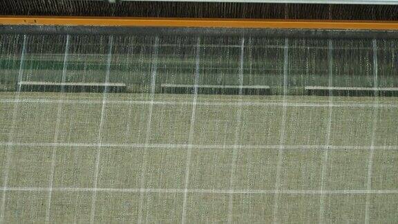 编织织机纺织工厂纺织工业特写镜头自动织布机正在织造线布纺织厂设备面料生产