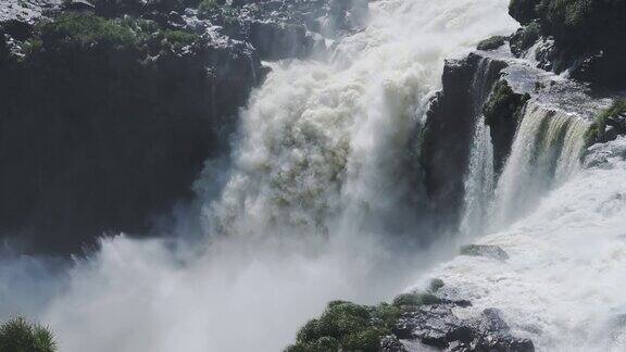 巨大的飞溅的水巨大的瀑布撞击到下面的大跳水池坚硬的侵蚀岩石景观从侵略性的瀑布水流在伊瓜苏瀑布阿根廷南美