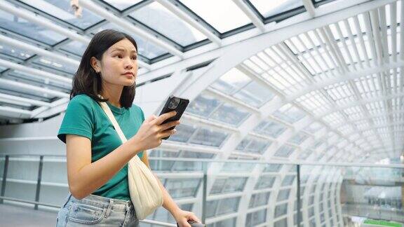 玩手机通讯在候机楼内等候登机的女子旅行