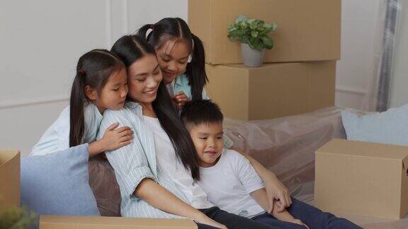 韩国孩子们坐在沙发上抱着妈妈