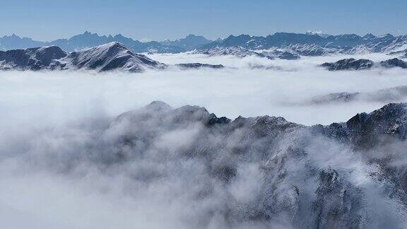 令人惊叹的空中冬季景观雪山山脉云雾蓝天下的中国四川嘉金山