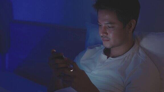 亚洲男人晚上在卧室的床上与朋友或女朋友在线聊天