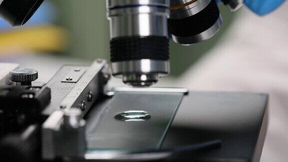 科学家将液体滴在显微镜玻璃上进行测试