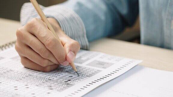学生用手做考题用铅笔写考题答题卡根据考试概念回答考题