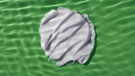 白色的奶油涂抹在绿色的背景下荡漾的水