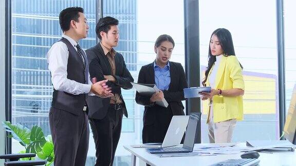 新常态办公室生活方式亚洲商人和女商人休闲站立会议会议一起与纸图表和平板电脑一起团队成就理念