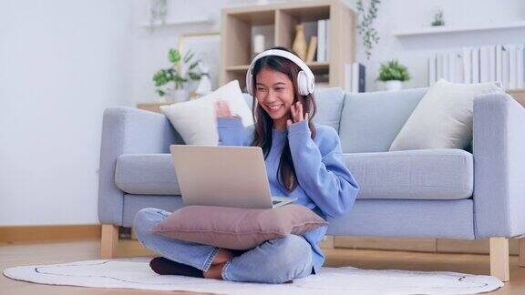 年轻的亚洲女性在舒适的家庭办公室用笔记本电脑进行视频通话-远程工作和技术概念