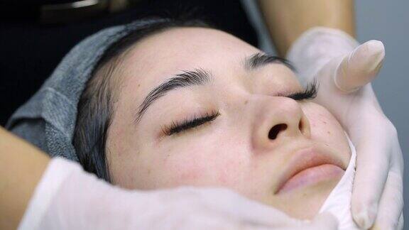 4K美容师在做面膜后清洁亚洲女性的脸