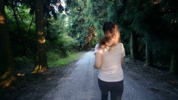 在森林小径上跑步的女人