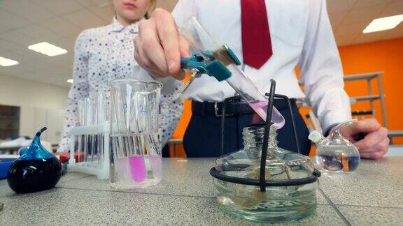 小学生在科学教室里加热试管做化学实验