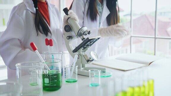 小学生在生物和科学课上使用显微镜的特写