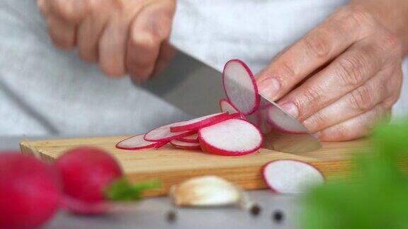 在厨房的砧板上用手切萝卜切蔬菜烹饪食物