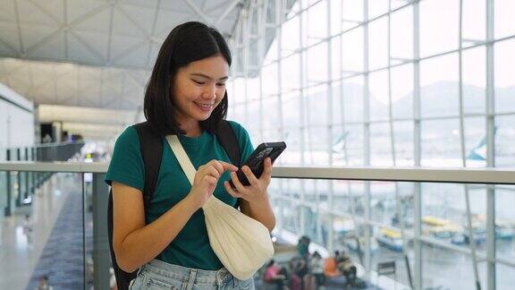 玩手机通讯在候机楼内等候登机的女子旅行