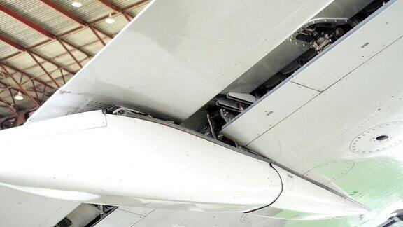 修理飞机修理一架客机的机翼襟翼飞行员检查机翼襟翼飞机正在机库中修理那架白色的飞机正在机库里修理4k