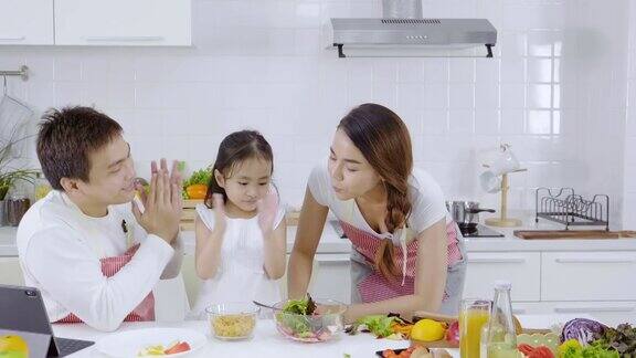 亚洲家庭和女儿一起在厨房做早餐