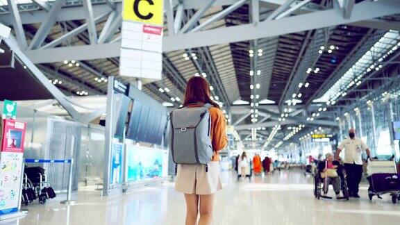 年轻的亚洲女性背包客走在繁忙的国际机场航站楼