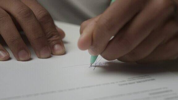 手在纸质文件上签名男人在签署协议拉近距离