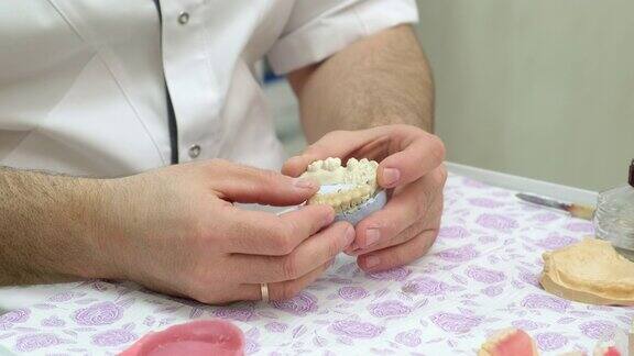 牙科技术员在实验室制作假牙时正在观察颌骨石膏模型