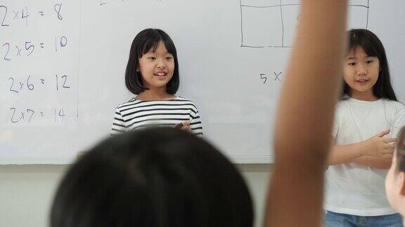 一个亚洲小女孩提出了一起思考数学答案的方法老师在学校的教室里教孩子们教育理念、经验学习和技能发展