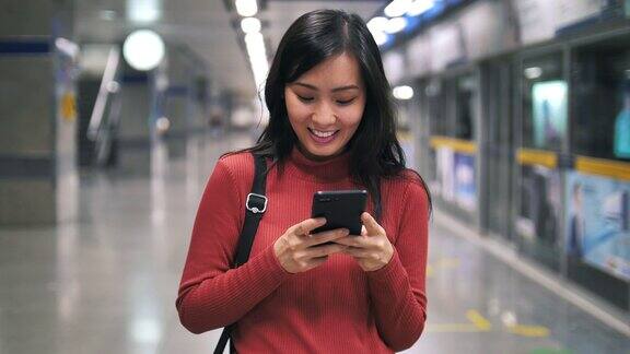 亚洲女性在地铁站使用智能手机