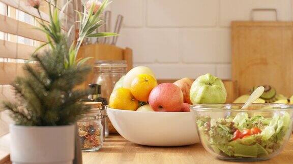 厨房柜台上准备早餐的一碗沙拉和许多水果的特写
