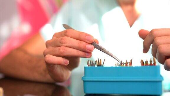 近距离的手使用镊子在牙科工具