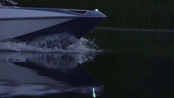 傍晚快速的摩托艇在河上漂浮船首切水