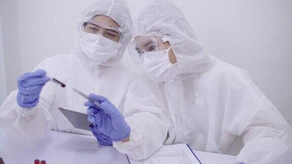 身穿全套防护服的专家科学家在分析生化实验室检测样本在试管中检测病毒