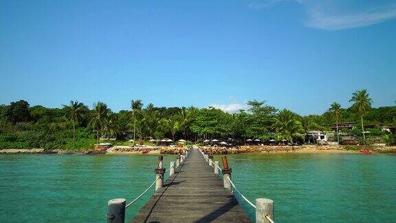 天堂岛的木头码头或桥美丽的热带海滩和椰子树周围的海洋
