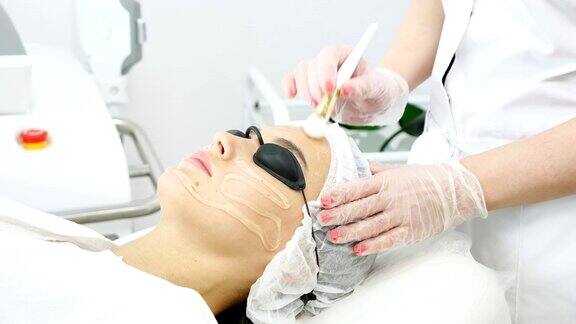 治疗师在女性病人脸上涂抹特殊软膏