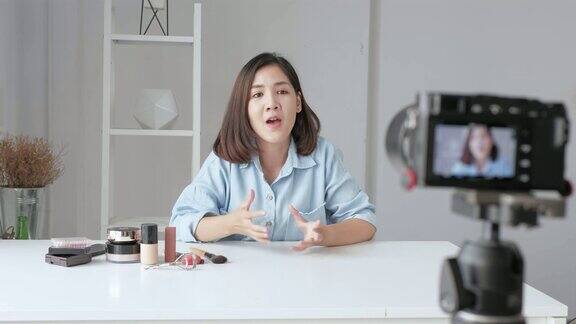 年轻的亚洲女性影响美时尚博主录制视频展示她的产品