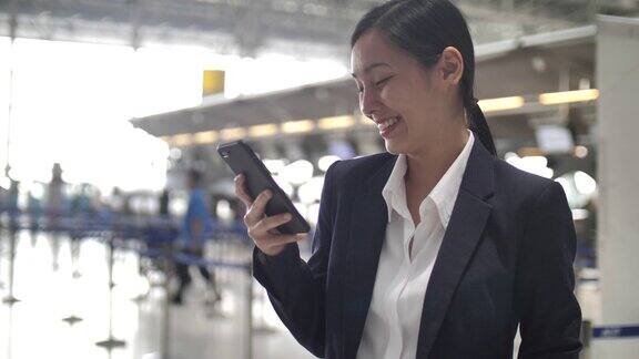 女商人在机场使用智能手机