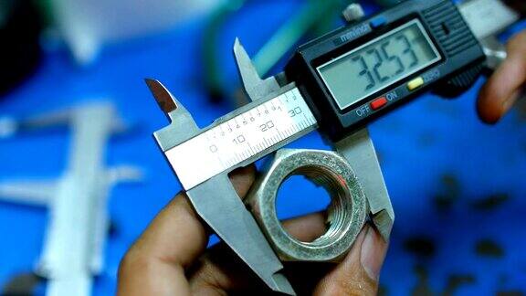 工人使用游标卡尺测量螺母的刻度