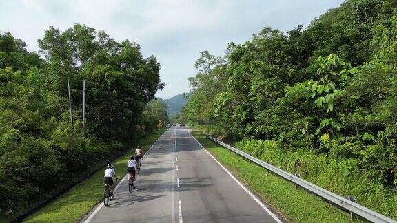 无人机在农村地区观看公路旅行3名亚洲中国女自行车手在早上骑自行车